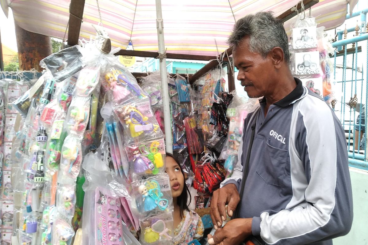 Juhari (74) saat menjual mainan di Surabaya, Jawa Timur, Kamis (23/1/2025)