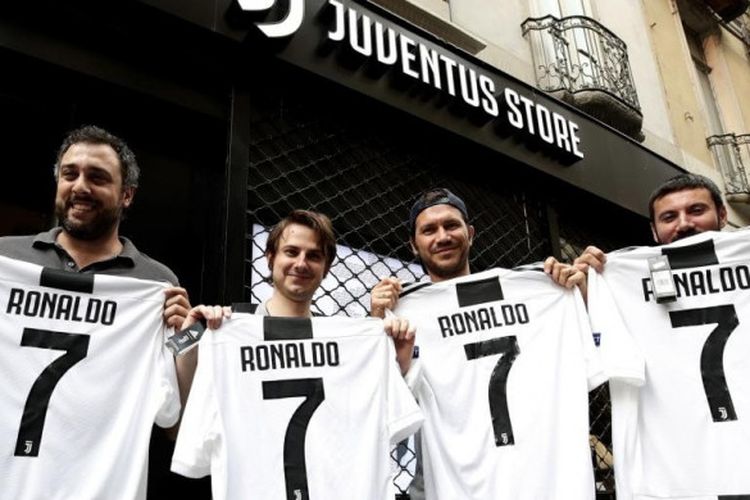 Para pendukung Juventus berpose dengan seragam nomor punggung 7 bertuliskan nama Cristiano Ronaldo di depan gerai Juventus Store di Turin, Senin (10/7/2018)