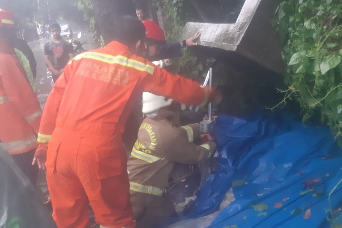 Anggota Sektor IX Pasar Minggu Suku Dinas Penanggulangan Kebakaran dan Penyelamatan Jakarta Selatan sedang menyelamatkan korban tertimpa tembok rubuh di Jalan Pejaten Raya dekat Universitas Nasional, Pejaten Barat, Pasar Minggu, Jakarta Selatan roboh pada Minggu (7/11/2021) sore.