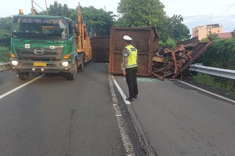 Sebuah truk trailer bermuatan besi tua terbalik di simpang susun Cawang (KM 0 Cawang Interchange), Jakarta, arah Cikampek, Selasa (19/10/2021) pagi.