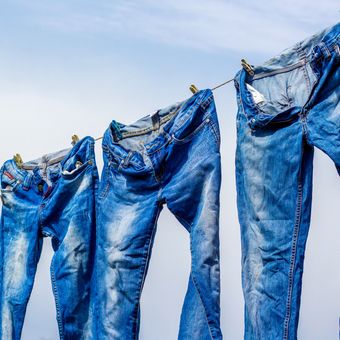 Ilustrasi mencuci dan mengeringkan celana jeans.