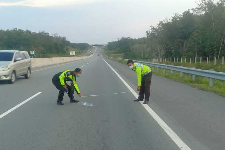 Petugas kepolisian lalu lintas melakukan olah TKP pada kasus kecelakaan di Jalan Tol Pekanbaru-Dumai, Senin (17/1/2022).
