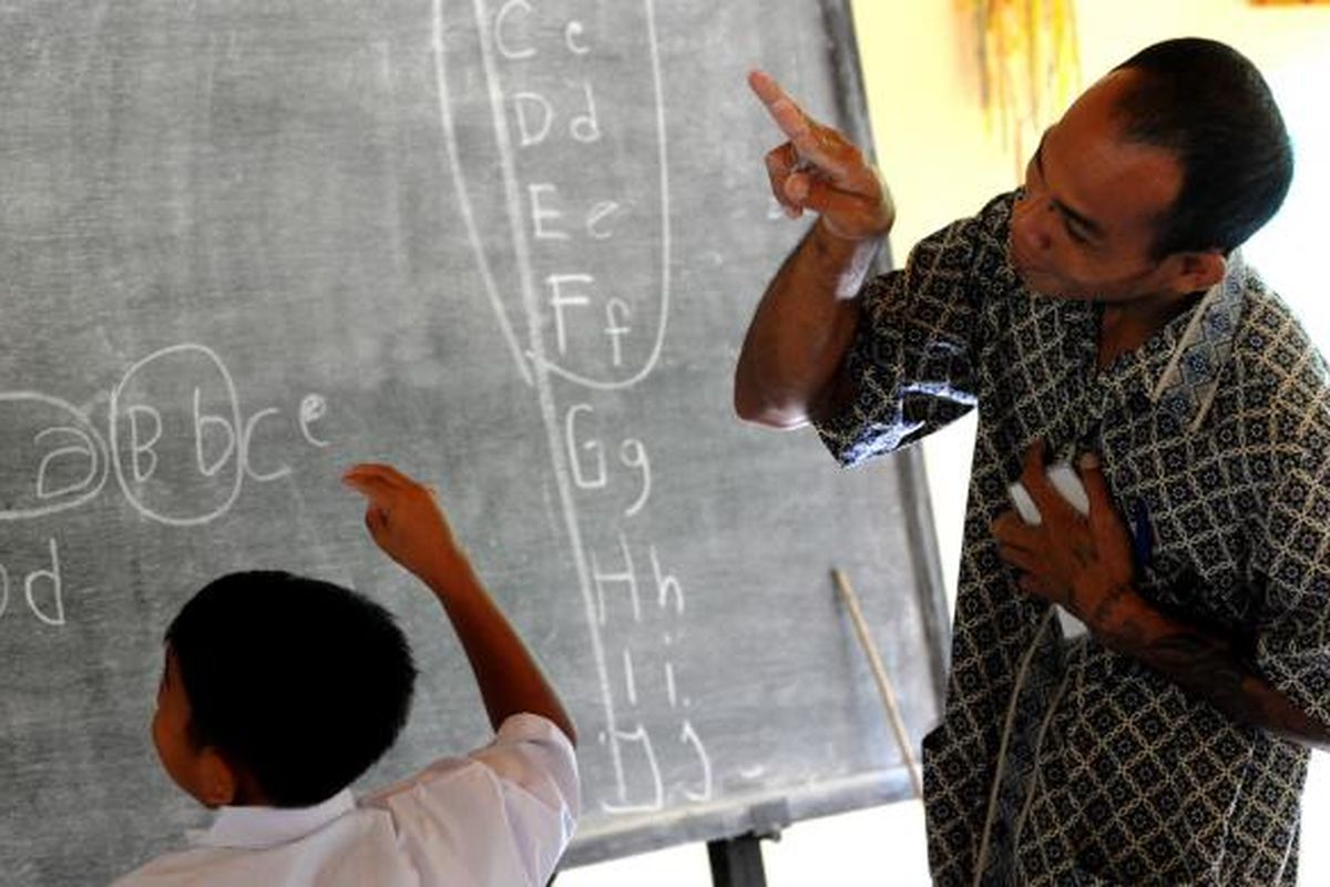 Guru mengajar menggunakan bahasa isyarat kepada seorang murid tunarungu di Sekolah Dasar, di Desa Bengkala, Singaraja, Bali, 20 Juli 2016. Desa Bengkala telah menjadi rumah bagi sejumlah besar penyandang tunarungu turun temurun.