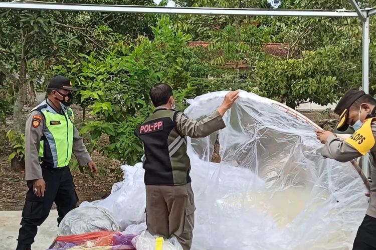 Petugas mengumpulkan balon udara hasil sitaan, di kantor Polsek Durenan Trenggalek Jawa timur,pada lebaran ketupat, Kamis (20/05/2021).