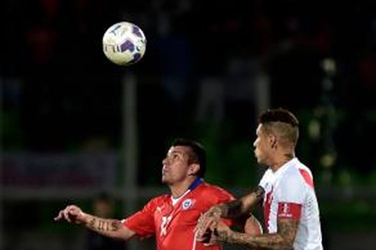 Pemain Cile, Gary Medel (kiri), berebut bola dengan pemain Peru, Paolo Guerrero, dalam laga uji coba di stadion Elias Figueroa di Valparaiso, Cile, Jumat (10/10/2014).