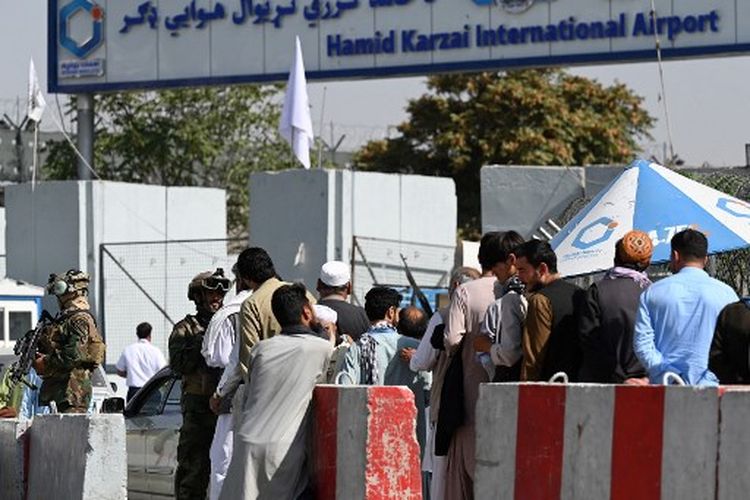 Anggota unit militer Taliban Badri 313 berjaga di pos pemeriksaan saat pekerja bandara mengantri untuk masuk ke Bandara Internasional Kabul di Kabul pada 4 September 2021. 