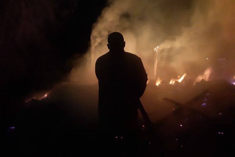 Petugas memadamkan api yang membakar kandang milik Sari di Desa Kedungsoko, Kecamatan Mantup, Lamongan, Jawa Timur, Kamis (23/11/2023) malam.