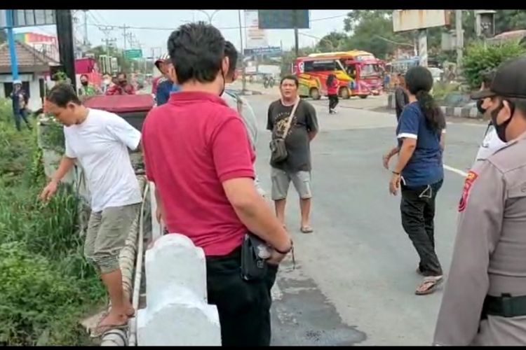 Polisi bersama warga berusaha mencegah seorang pria yang hendak terjun ke Sungai Kemiri, Kota Tegal, Jawa Tengah, Selasa (21/12/2021) (Istimewa)