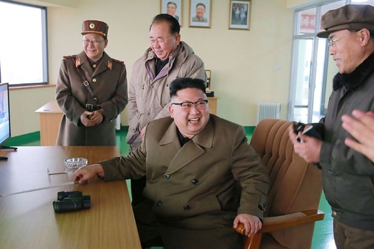 Pemimpin Korea Utara Kim Jong Un tersenyum lebar saat menyaksikan uji coba rudal di pusat peluncuran Sohae, Korea Utara.