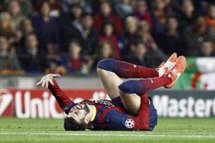 Bek Barcelona Gerard Pique terjatuh setelah berebut bola dengan penyerang Atletico Madrid, Diego Costa, pada pertandingan leg pertama perempat final Liga Champions, di Camp Nou, Selasa (1/4/2014). Akibatnya, Pique mengalami cedera pada panggul kanan sehingga digantikan Marc Bartra.