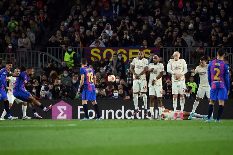 Memphis Depay (kiri) saat melakukan tendangan bebas dalam pertandingan Barcelona vs Galatasaray pada leg pertama babak 16 besar Liga Europa di Stadion Camp Nou, Jumat (11/3/2022) dini hari WIB. Artikel ini menyajikan proses terjadinya tendangan bebas dalam permainan sepak bola.