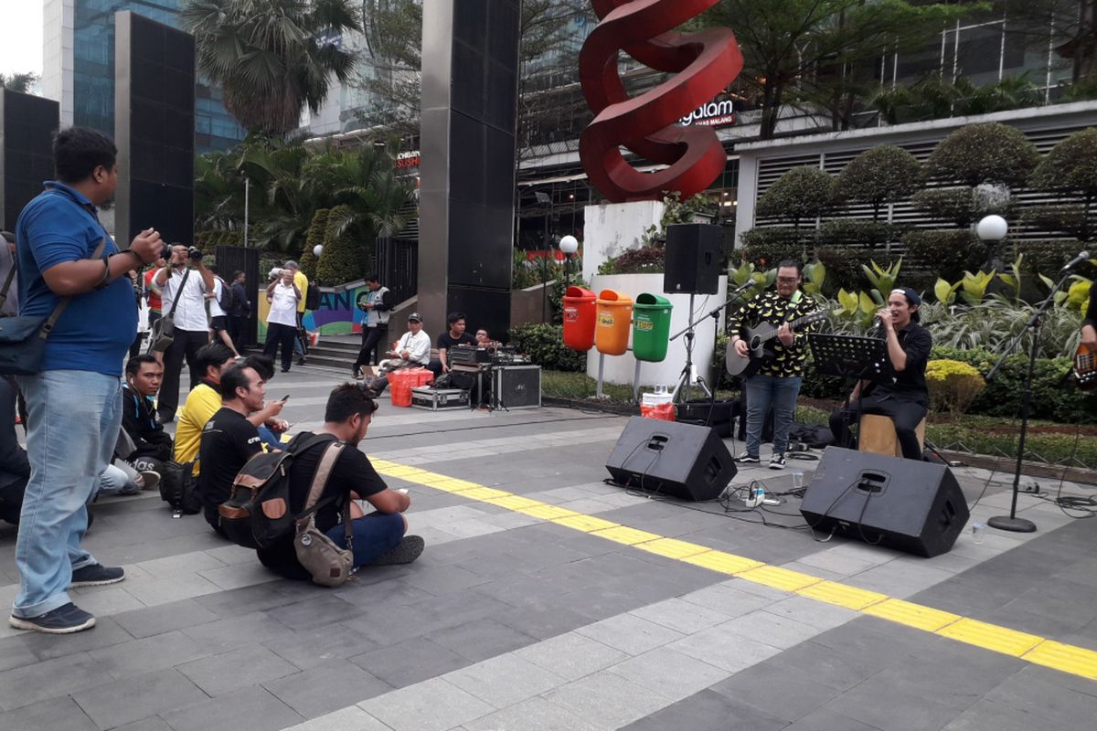 Warga lesehan menikmati pertunjukan musik di trotoar sudirman, Rabu (29/8/2018)