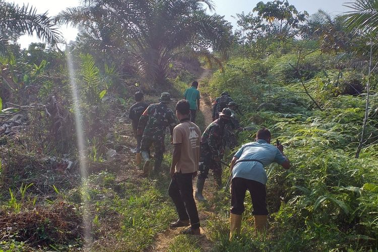 Prajurit TNI dibantu petani membuka jalan di hari pertama kerja Program TMMD ke 110 di Desa Koto Ranah, Kecamatan Kabun, Kabupaten Rohul, Provinsi Riau, Selasa (2/3/2021).