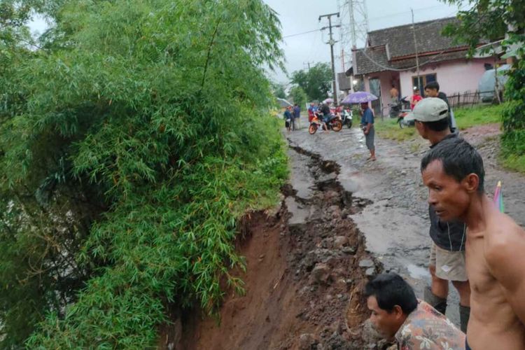 Sejumlah warga memeriksa kondisi tebing jalan yang longsor di wilayah selatan Cianjur, Jawa Barat, akibat curah hujan tinggi, Minggu (15/11/2020).