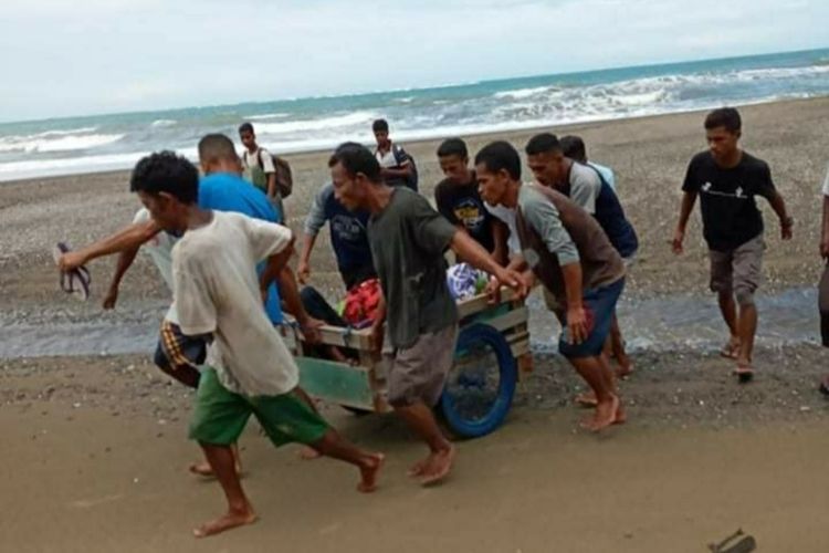 Puluhan warga Desa Desa Misinh, Kecamatan Kilmuri, Kabupaten Seram Bagian Timur membawa seorang warga yang sakit dengan gerobak menuju puskesmas di Kilmuri, Minggu (21/2/2021)