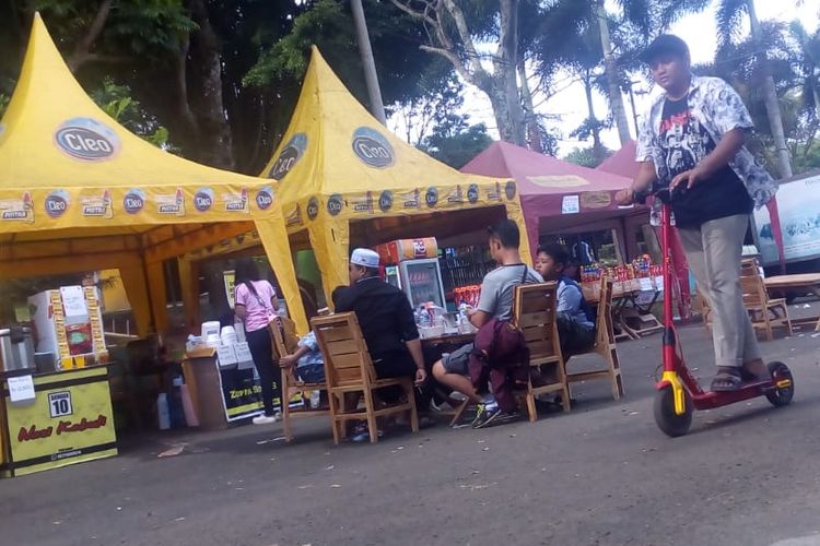 Seorang pengunjung sedang menaiki skuter elektrik yang disewakan di Kawasan Wisata Waduk Darma di Kuningan, Jawa Barat.