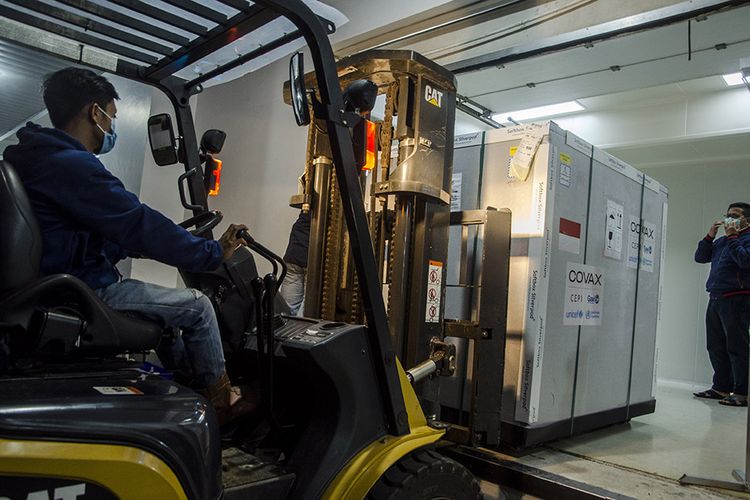 Employees unload an envirotainer containing AstraZeneca?s COVID-19 vaccine upon arrival at Bio Farma, Bandung, West Java, Monday, March 8, 2021.