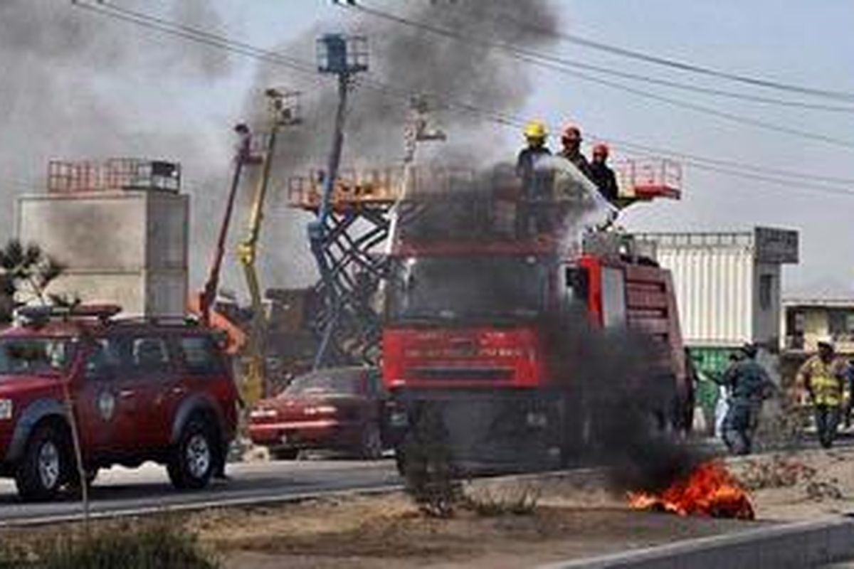 Pasukan pemadam kebakaran berusaha memadamkan api yang disulut para pengunjuk rasa di kota Kabul, Afganistan.