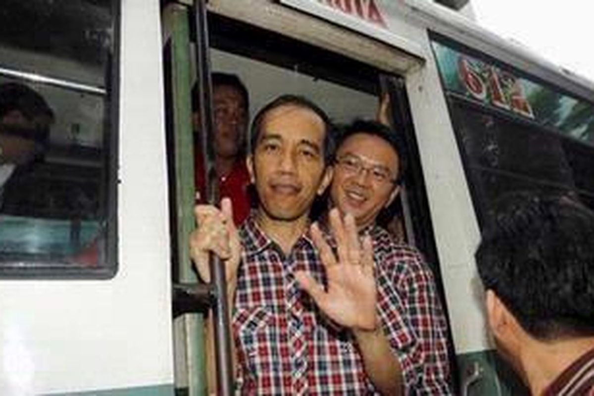 Joko Widodo atau Jokowi (kanan) dan Basuki Tjahja Purnama (Ahok) menumpangi angkutan umum saat menuju kantor Komisi Pemilihan Umum Daerah, Jalan Budi Kemuliaan, Gambir, Jakarta Pusat, Senin (19/3/2012).  