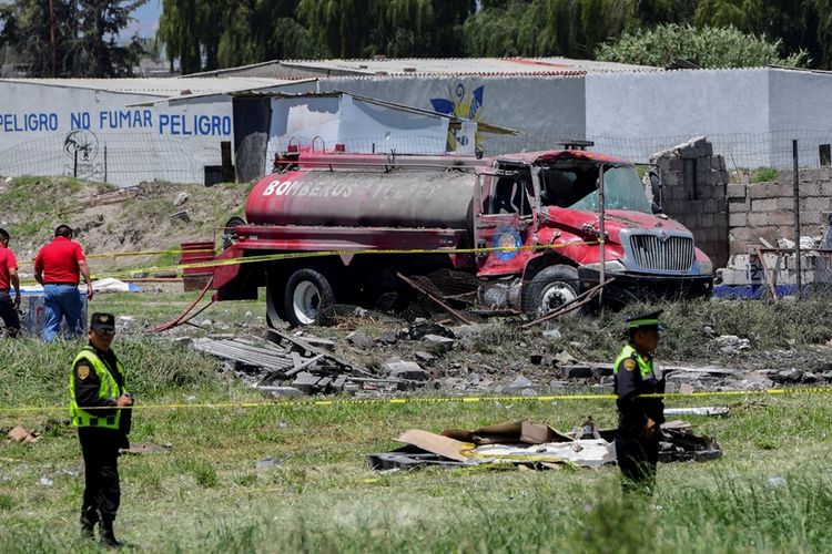 Petugas kepolisian berjaga di sekitar lokasi ledakan gudang penyimpanan kembang api yang meratakan empat bangunan di kota Tultepec, Meksiko tengah, Kamis (5/7/2018).