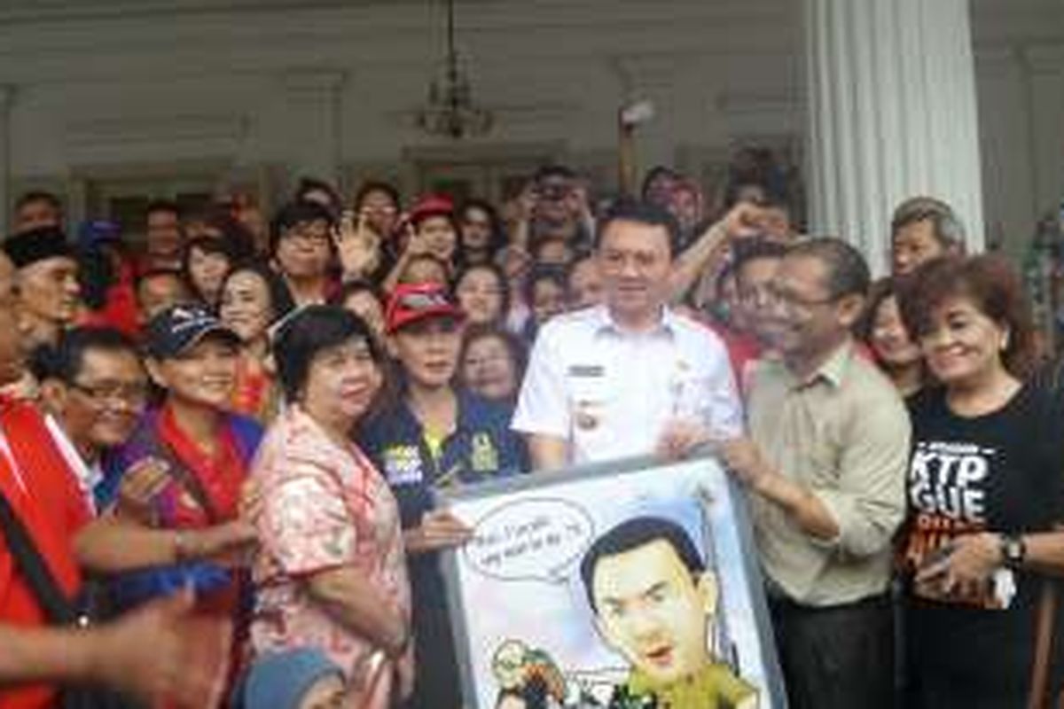 Gubernur DKI Jakarta Basuki Tjahaja Purnama mendapat hadiah lukisan dari relawannya di Balai Kota DKI Jakarta, Rabu (29/6/2016). 