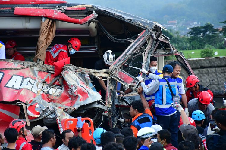 Sejumlah petugas melakukan proses evakuasi bus pariwisata yang terlibat kecelakaan di Tol Malang KM 77+200 Jalan Tol Pandaan-Malang, Lawang, Kabupaten Malang, Jawa Timur, Senin (23/12/2024). Berdasarkan data temuan awal Polres Malang, kecelakaan bus pariwisata dan truk tersebut menyebabkan empat orang meninggal dunia. 