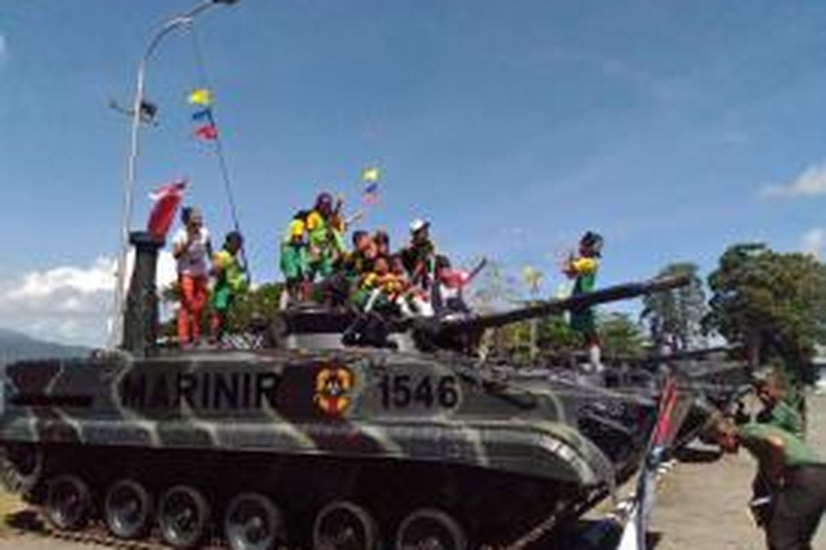 Warga dan anak-anak sekolah naik diatas tank dalam  pameran alutsista TNI yang digelar di lapangan Lantamal IX Ambon, Minggu (22/11/2015) 