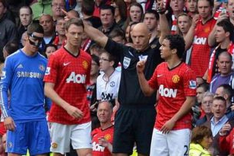 Bek Manchester United, Rafael da Silva (kanan), mendapatkan kartu merah dari wasit Howard Webb, karena melanggar bek Chelsea, David Luiz (tidak tampak), pada pertandingan Premier League, di Old Trafford, Minggu (5/5/2013).