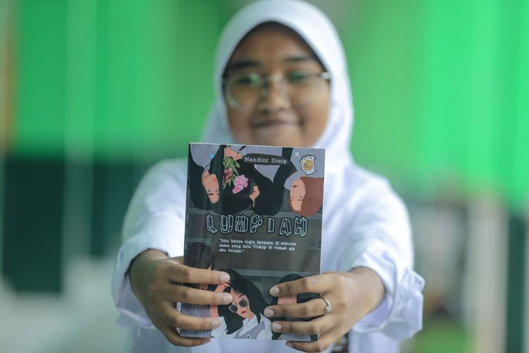 Siswi SMAN 1 Batujajar Bandung Barat, Nandini Sinta Putri memegang bukunya berjudul Lumpiah.