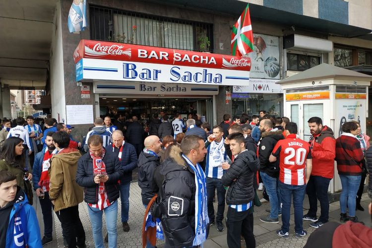 Para suporter Real Sociedad dan Athletic Bilbao bercengkrama bersama di depan sebuah bar sebelum masuk ke dalam stadion.
