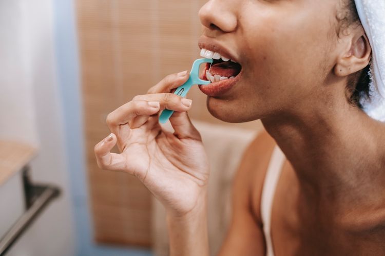 Rutin flossing, setidaknya sehari sekali, dapat membantu sebagai salah satu cara menghilangkan bau mulut.