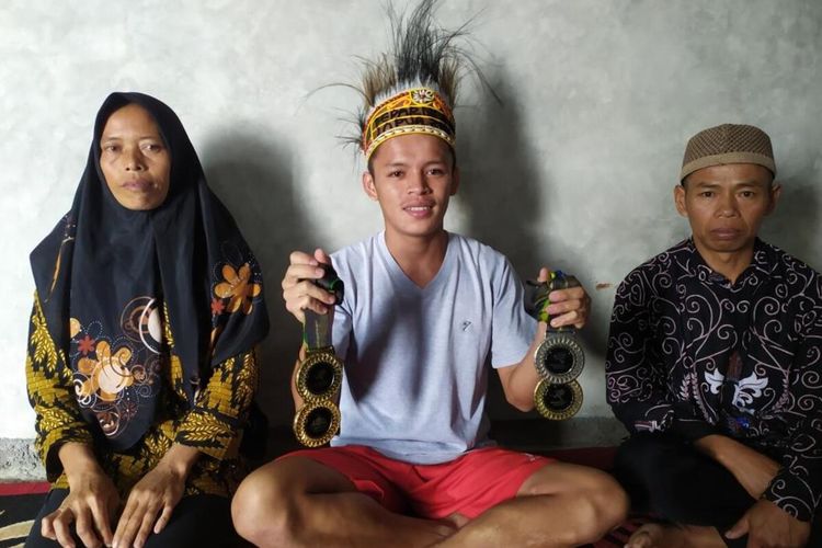Partin (19) peraih emas di Peparnas XVI Papua 2021 bersama dua orangtuanya di rumahnya di Dusun Wonocoyo, Desa Kaliangrik, Kecamatan Kaliangkrik, Kabupaten Magelang, Jawa Tengah, Rabu (17/11/2021).