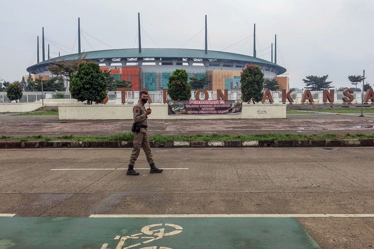 Petugas Satpol PP berjaga di jalan Kolonel Egi Yoso Martadipura yang ditutup, kawasan Stadion Pakansari, Kabupaten Bogor, Jawa Barat, Minggu (24/1/2021).  Pemerintah memutuskan memperpanjang pemberlakuan pembatasan kegiatan masyarakat (PPKM) Jawa-Bali lantaran masih tingginya kasus aktif COVID-19 di beberapa daerah tersebut. Perpanjangan terhitung mulai 26 Januari hingga 8 Februari 2021. ANTARA FOTO/Yulius Satria Wijaya/foc.