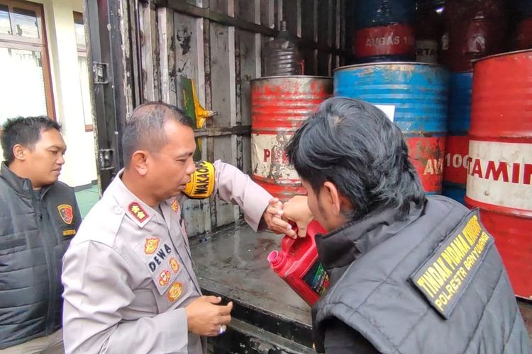 Polisi saat menunjukkan barang bukti pengungkapan penimbunan solar bersubsidi di Banyuwangi, Selasa (18/7/2023)