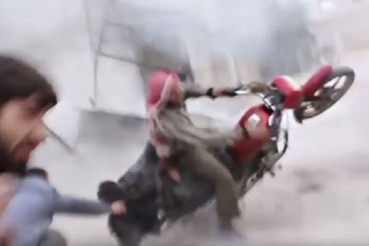 Foto yang diambil dari rekaman video ini memperlihatkan sebuah sepeda motor terpelanting ketika bom akibat serangan udara jatuh tak jauh dari sepeda motor itu.