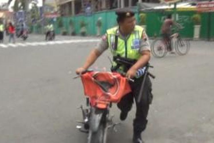 Petugas kepolisian mengamankan sebuah sepeda motor milik peserta kampanye, Sabtu (5/4/2014). 