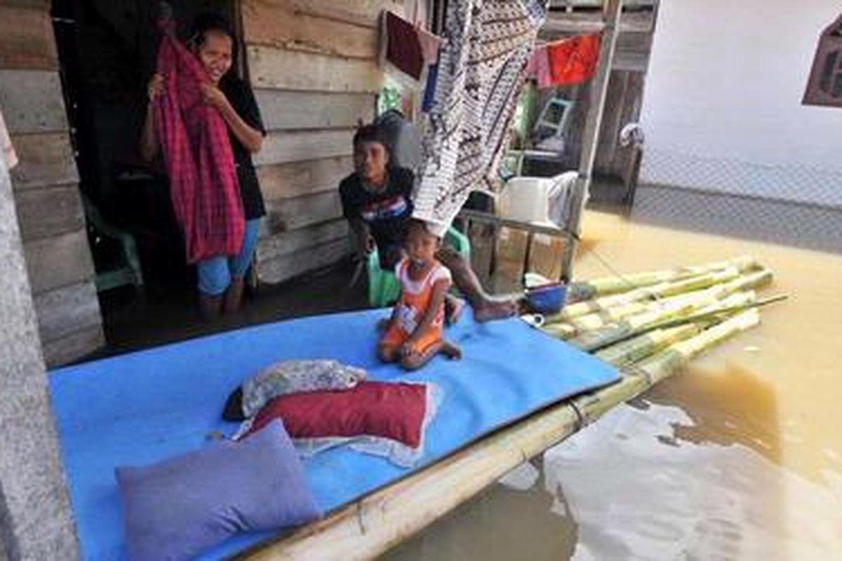 Warga menggnakan batang pisang untuk rakit di lokasi banjir. 