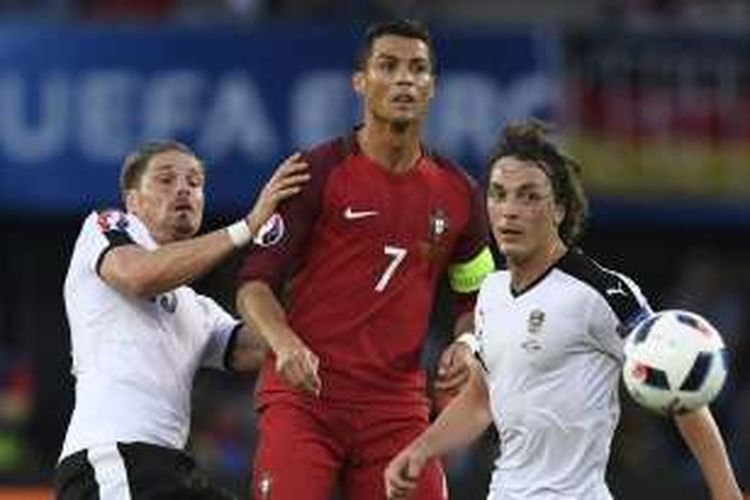 Pemain bintang Portugal, Cristiano Ronaldo (tengah), mendapatkan pengawalan ketat dari dua pemain Austria, pada laga Grup F Piala Eropa 2016 di Parc des Princes, Paris, pada Sabtu (18/6/2016) waktu setempat.
