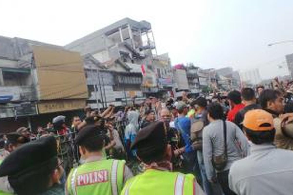 Warga Kampung Pulo melawan saat rumahnya hendak ditertibkan oleh petugas, Kamis (20/8/2015).