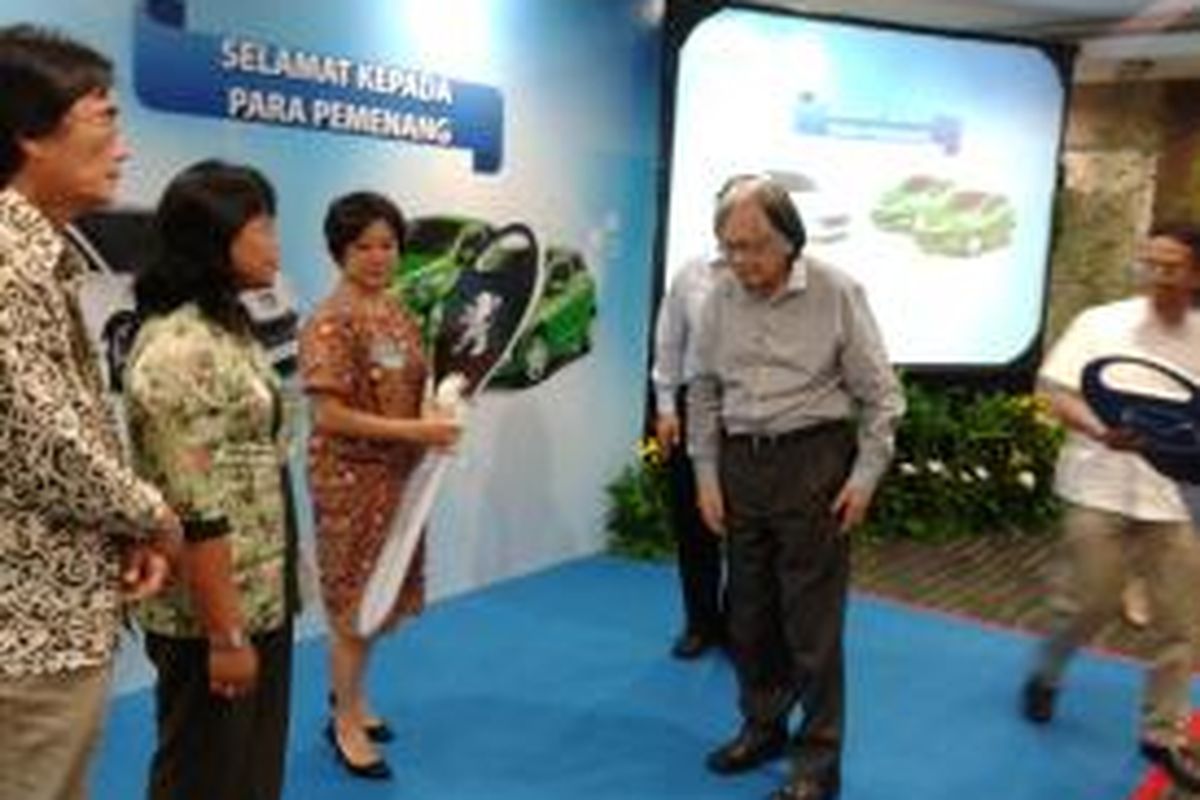 Ester Setibudi saat berpose dengan Peugeot RCZ di Gedung Kompas Gramedia, Jakarta, Senin (22/7/2013). Ester merupakan warga Kudus, Jawa Tengah yang telah berlangganan Harian Kompas selama 20 tahun. Ester menjadi pemenang utama dalam undian Gempita Kompas