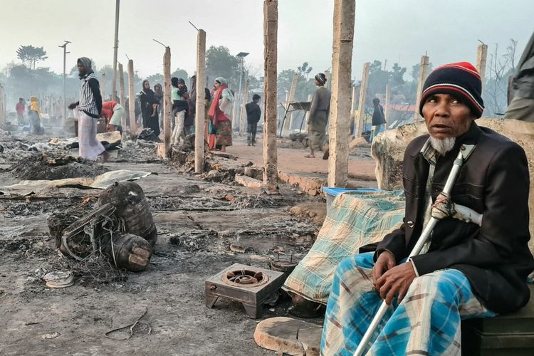 Seorang pengungsi Rohingya duduk di antara puing-puing rumahnya yang hangus akibat kebakaran hebat di kamp Ukhia, Cox's Bazaar pada dini hari tanggal 7 Januari 2024. Sekitar 4.000 pengungsi Rohingya di Bangladesh tidak memiliki tempat berlindung setelah serangan yang diduga akibat pembakaran melanda kamp mereka dan menghanguskan hampir 800 rumah, kata seorang pejabat pada 7 Januari.
