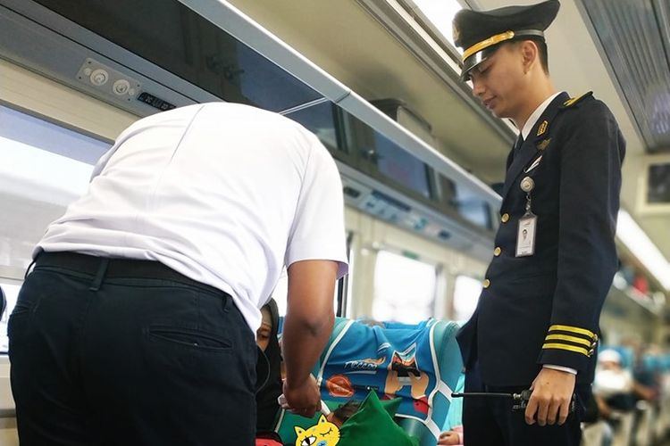 Kondektur dan petugas kereta membantu penumpang anak yang tengah sakit