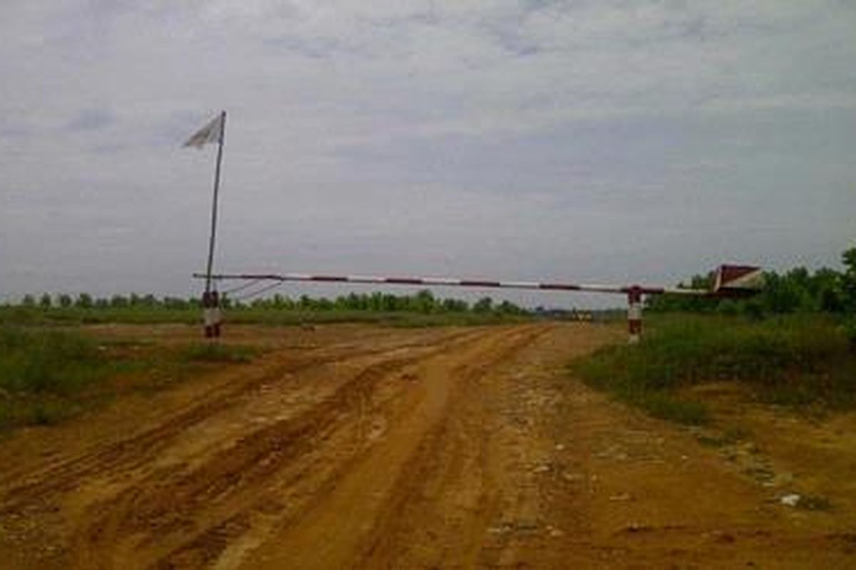 Jalan masuk menuju kawasan Register 45, Mesuji, di Tugu Roda ditutup portal dan digembok oleh warga, Jumat (2/3/2012).