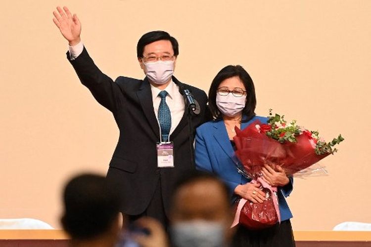 John Lee (kiri) dan istrinya Janet (kanan) melakukan perayaan setelah Lee dinobatkan sebagai pemimpin baru kota di Hong Kong pada 8 Mei 2022. John Lee, mantan kepala keamanan yang mengawasi tindakan keras terhadap gerakan demokrasi Hong Kong, diklerasikan menjadi pemimpin baru pusat bisnis pada 8 Mei 2022 oleh komite kecil loyalis Beijing.