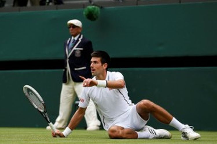 Petenis Serbia,  Novak Djokovic, terjatuh saat menghadapi Florian Mayer dari Jerman, di babak pertama Wimbledon, Selasa (25/6/2013).