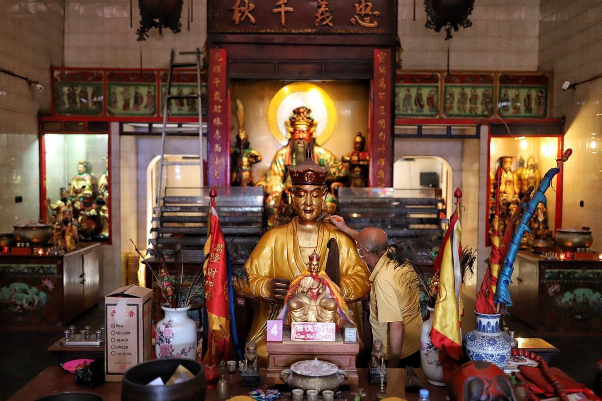 Seorang petugas tengah membersihkan patung dalam menyambut perayaan Imlek yang jatuh pada 1 Februari 2022. 