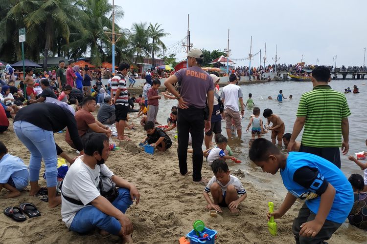 Keramaian wisatawan di Pantai Indah, Ancol, pada hari kedua libur Idul Fitri, Selasa (3/5/2022).