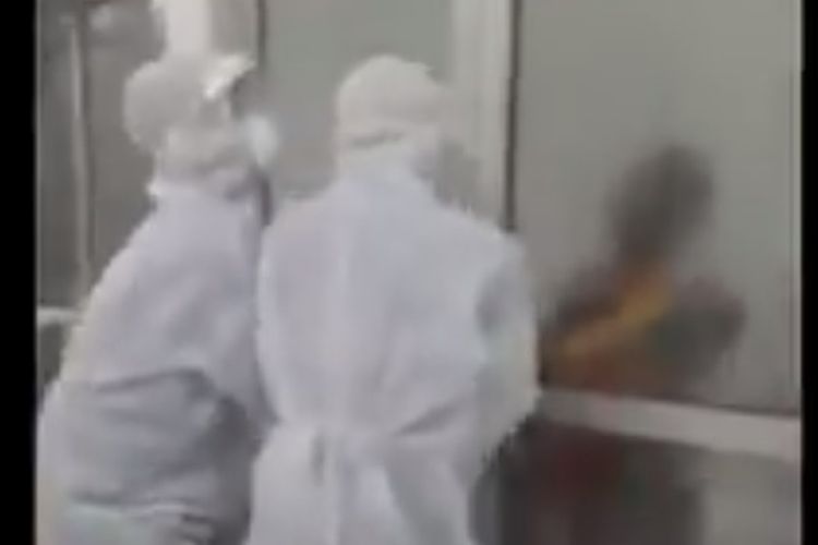 Viral di media sosial video seorang kakek berstatus pasien dalam pengawasan (PDP) mencoba membuka paksa pintu yang dijaga dua orang yang mengenakan baju hazmat (APD).