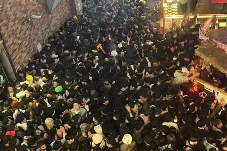 Kerumunan orang-orang yang berdesakan di gang atau lorong sempit di Distrik Itaewon, Seoul.

