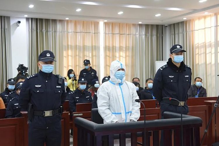 Zeng Chunliang (tengah) memakai setelan APD lengkap saat menghadiri sidang yang menjatuhkan hukuman mati padanya, Senin (11/1/2021) di Yichun, China. Pria berusia 45 tahun itu melakukan pembunuhan berantai dengan korban sepasang lansia dan satu pejabat desa. Motif pembunuhannya karena balas dendam.